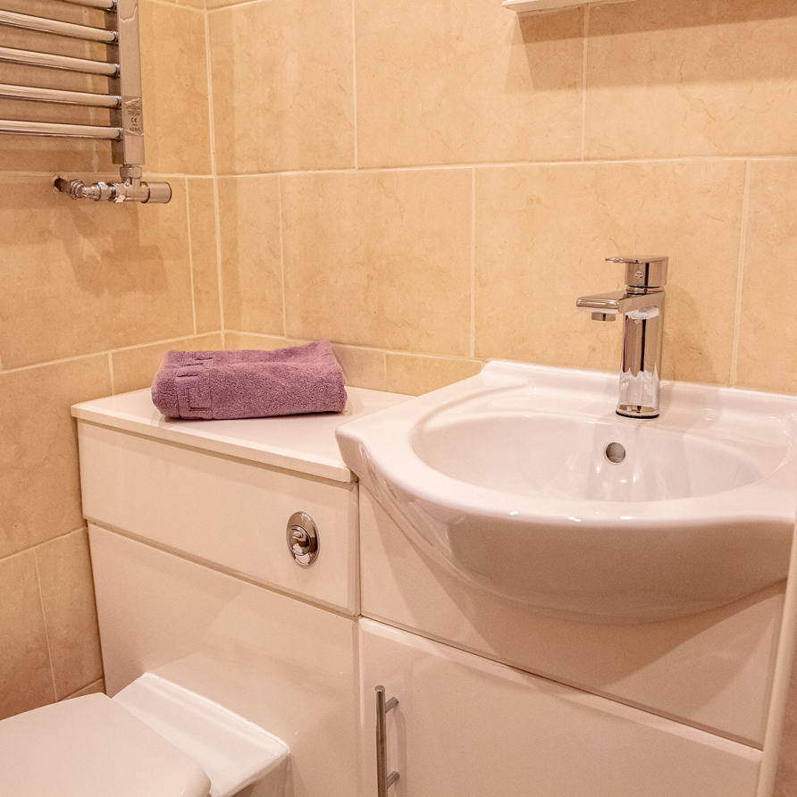 A clean bathroom with a face towel folded neatly on show